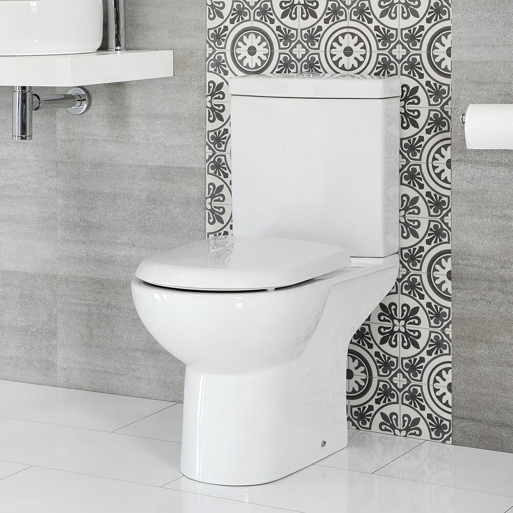 WC moderno monobloque blanco con cisterna sobre suelo con azulejos blancos