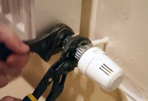 Mantenimiento del husillo de llave y reparación de un goteo de agua del radiador con una llave inglesa