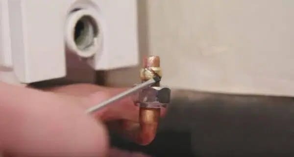 Cómo arreglar el goteo de un radiador al extraer la férula de una llave de radiador con destornillador