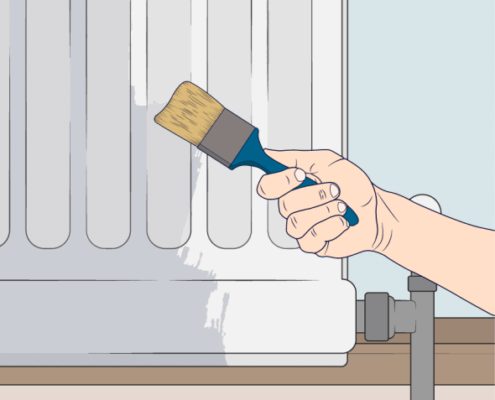 Una mano con piel clara sostiene un pincel con mango azul y cerdas marrones, pintando el costado de un radiador blanco de paneles verticales. Se observa una capa de pintura blanca fresca en el radiador, que está sobre un zócalo de madera y contra una pared azul claro.